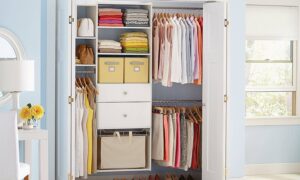 A neatly organized closet featuring folded clothes, hanging blouses, and skirts, with storage bins and a stylish lamp nearby.