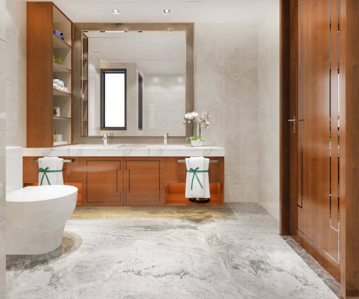  A modern bathroom featuring a marble floor, wooden cabinetry, a large mirror, and a stylish door, adorned with green-accented towels.