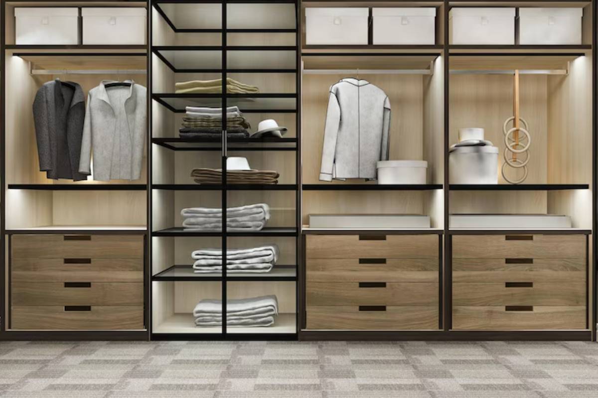 A modern closet featuring neatly hung clothes, stacked towels, and organized storage boxes, illuminated by soft lighting.