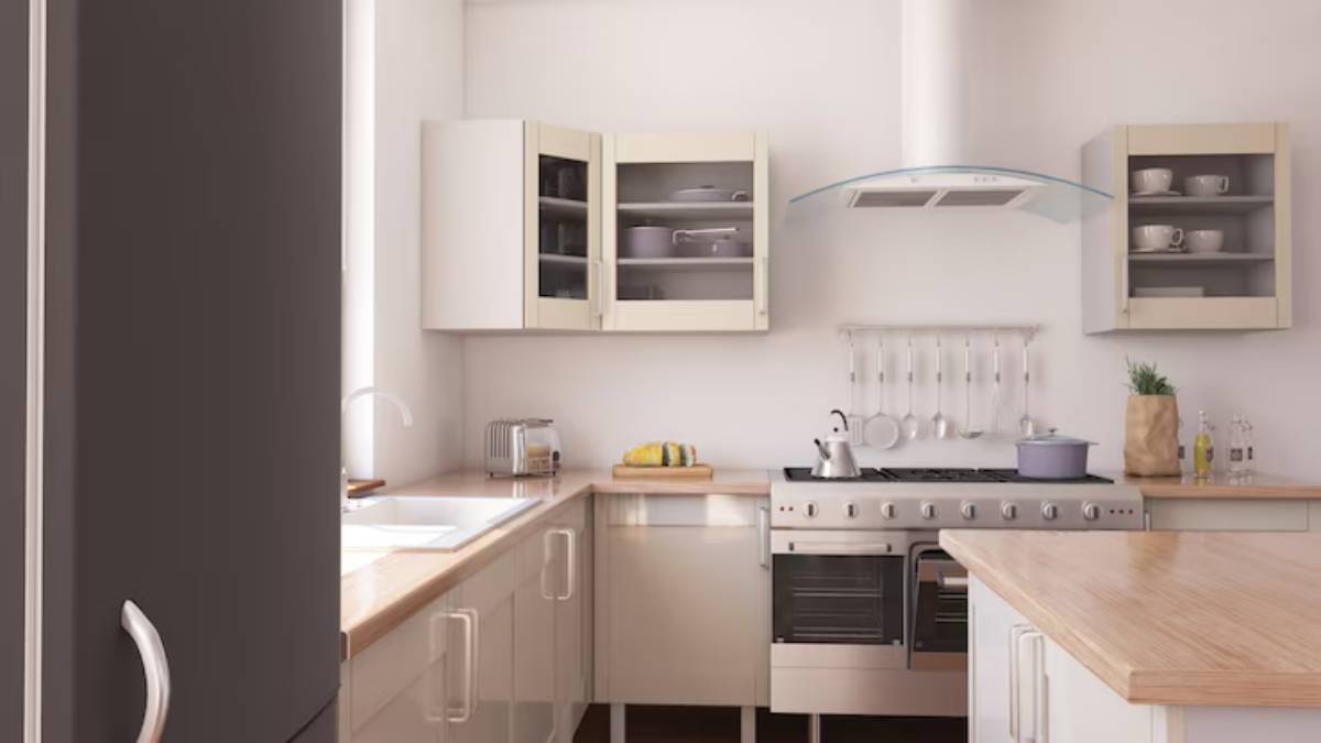 Modern kitchen featuring light cabinets, wooden countertops, stainless steel appliances, and a stylish range hood with cookware.