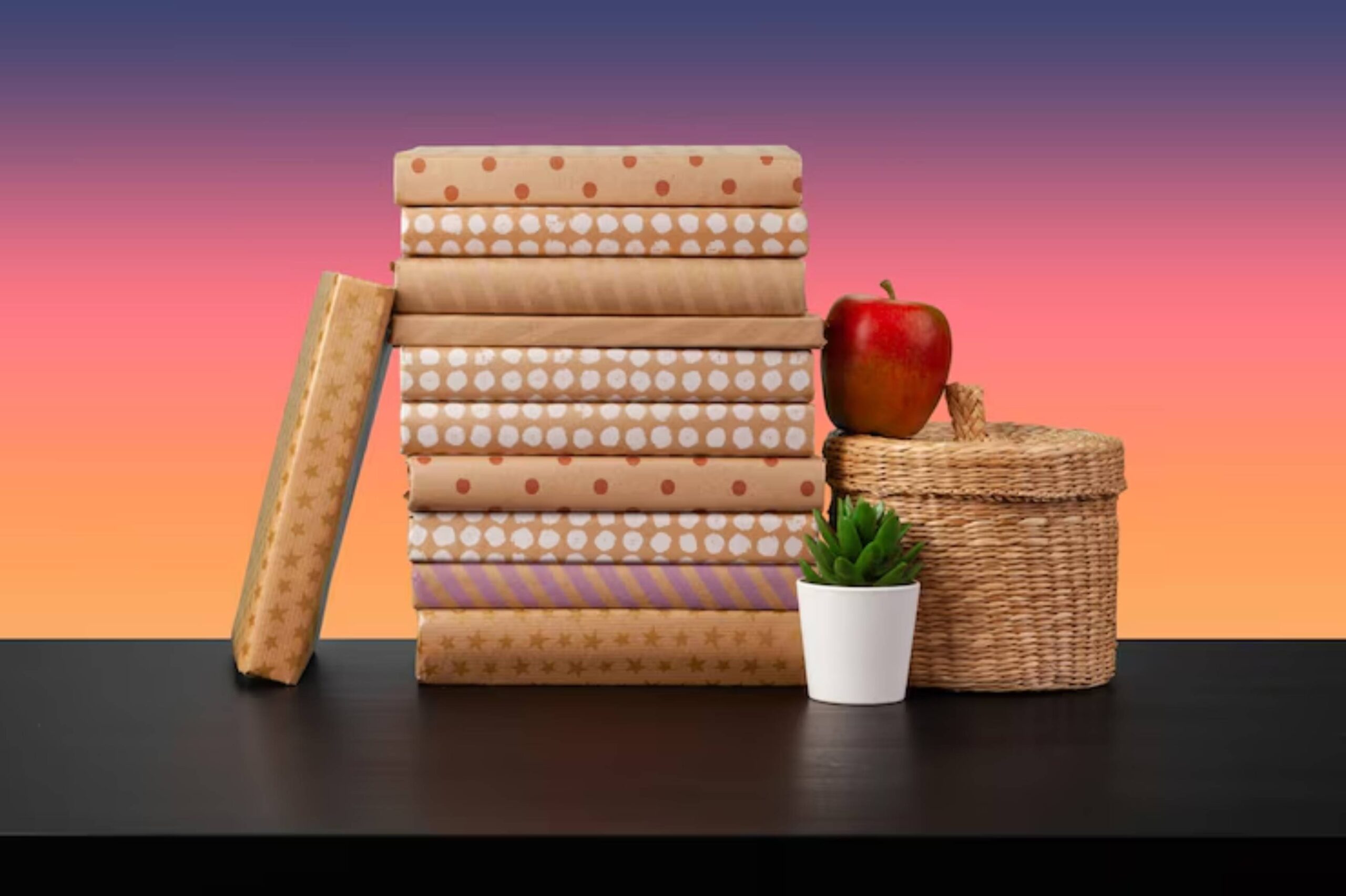 A stack of neatly wrapped books with various patterns, an apple, a small potted plant, and a woven basket against a gradient background.